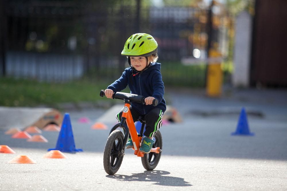 A toddler in gear riding a balance bike