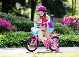 Girl riding a bike with training wheels