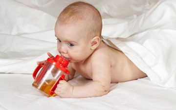 baby with a baby cereal bottle feeder