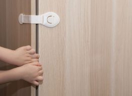 sliding door safety lock - hands of a kid trying to open a safety locked door