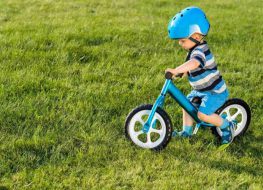 toddler bike without pedals - toddler boy riding a blue balance bike