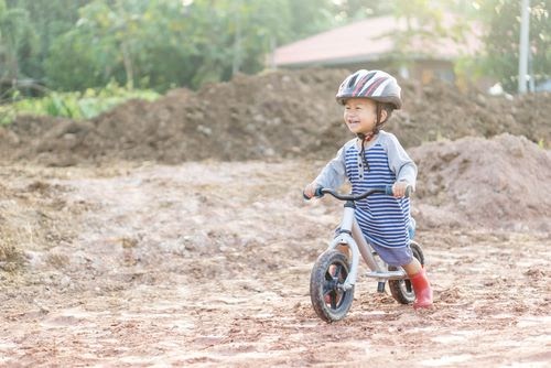Best toddler bike helmet - toddler boy playing in the mud