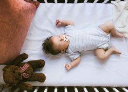 baby sleeping comfortable on a crib with mattress
