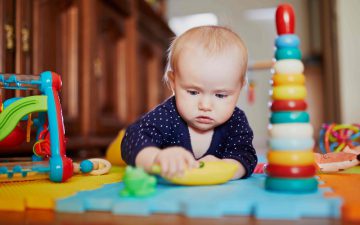 baby with toys on foam tiles play mat