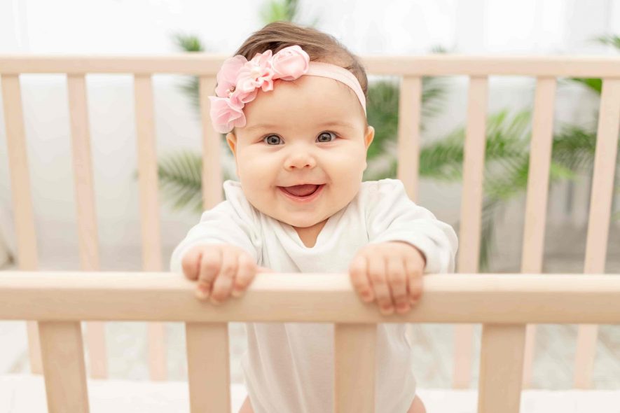 cute baby girl on wooden crib  