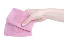 baby knee pads - hand holding a pair of pink baby knee pads