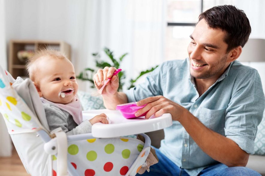 dad feeding his baby using bowl and spoon set