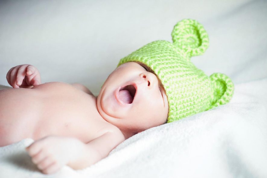 drowsy baby with a green bonnet
