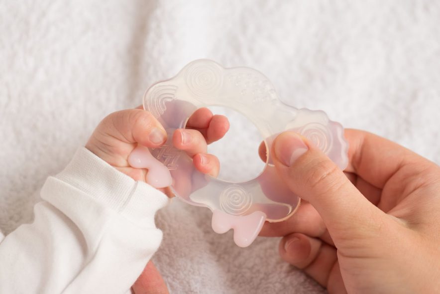 mother and her baby holding a teether