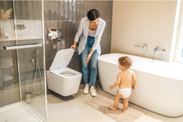 A parent teaching her child how to use the toilet