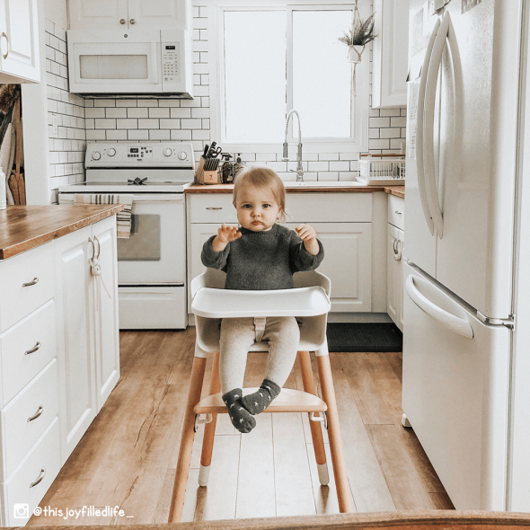 A boy on an Ashtonbee convertible high chair in the kitchen 