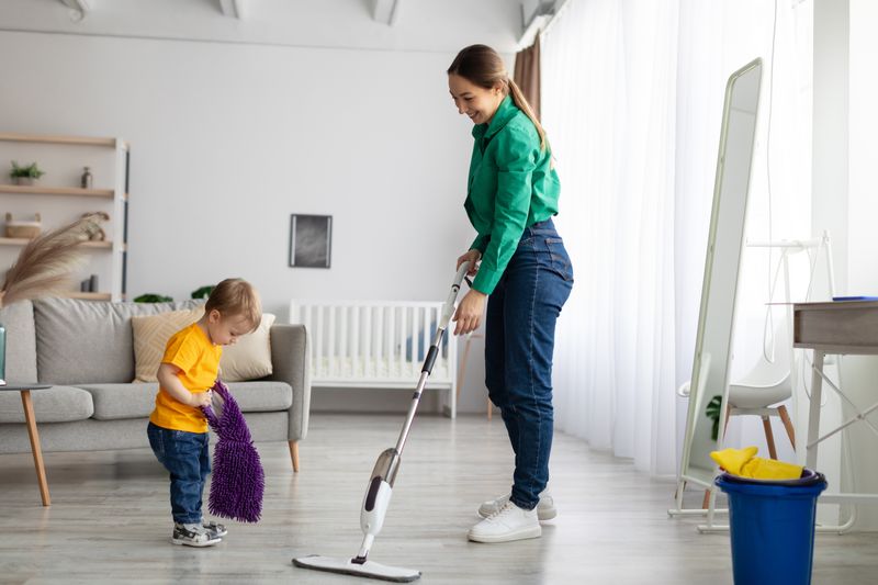 Letting your child learn on his own - A baby and his mother cleaning the house 