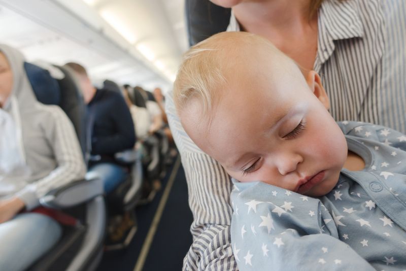https://www.ashtonbee.com/wp-content/uploads/2022/08/Baby-sleeping-during-flights-with-no-infant-head-shaping-pillow.jpg