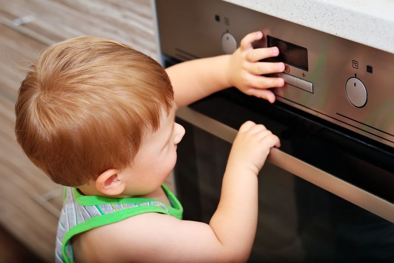 Child touching an electric oven