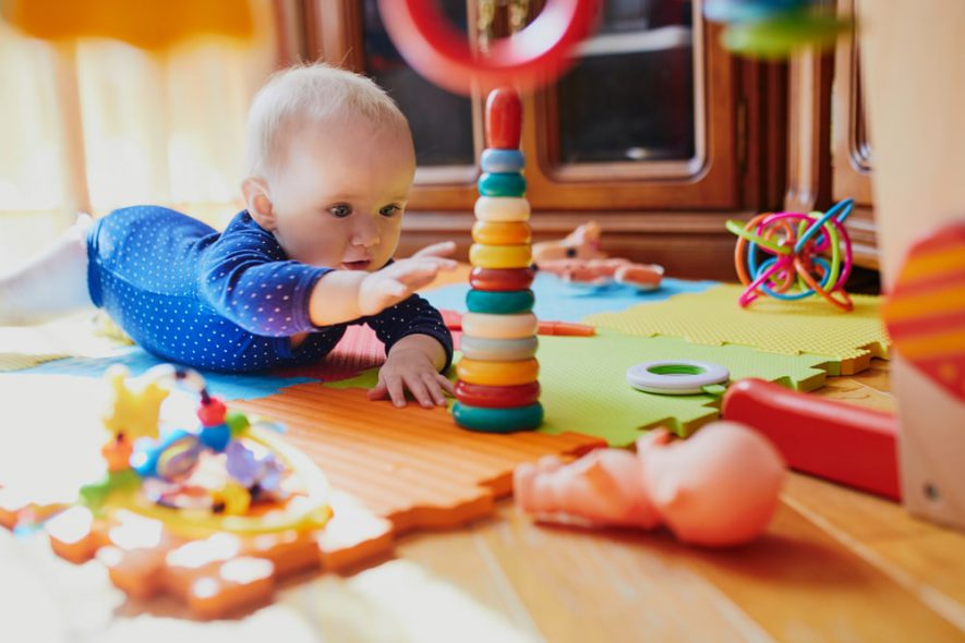 baby on mat with toys 