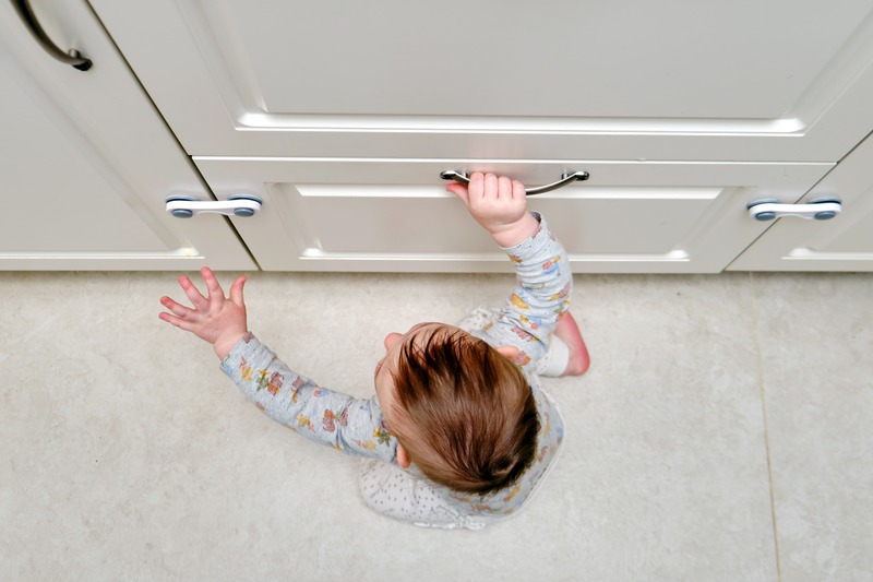cabinet drawer locks - top view of baby trying to open drawers and cabinet lock