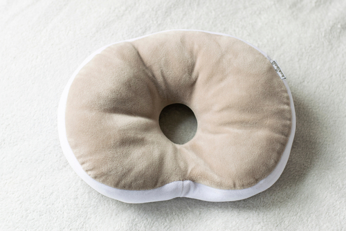 photo of a brownish grey head-shaping pillow for babies