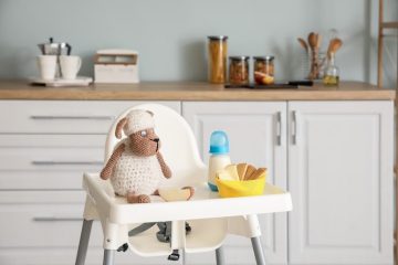a toddler chair with food and toy in the kitchen