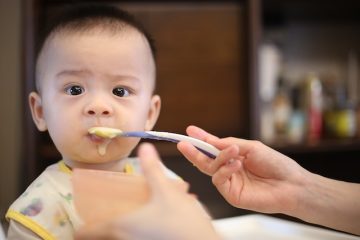 Parent spoon feeding their baby