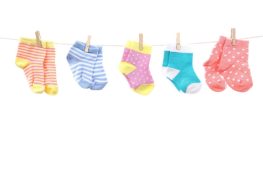 Different-colored baby socks hanging on a miniature clothesline.