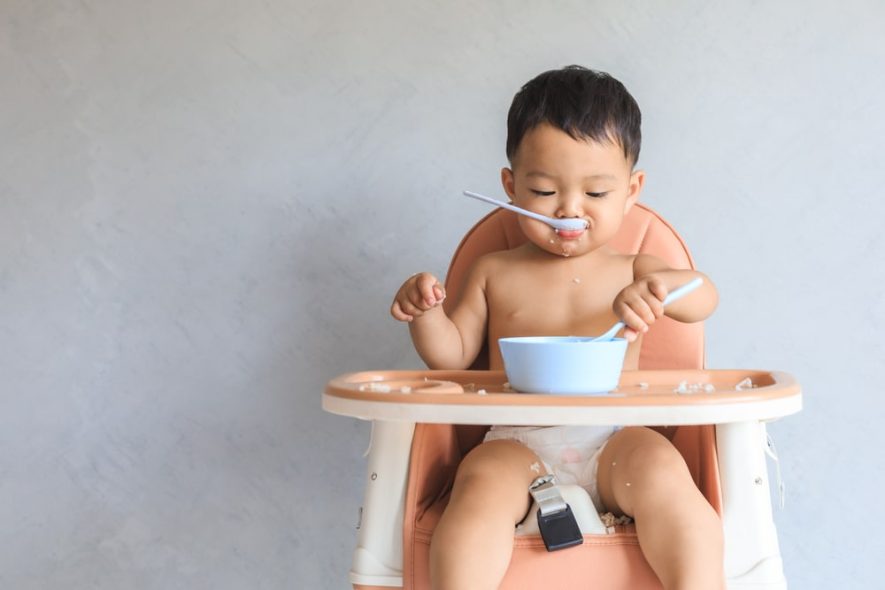 toddler eating on high chair