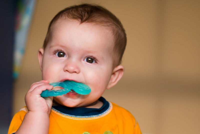 A child chewing on a silicone baby teether