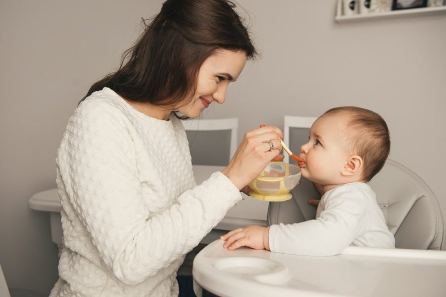 mom feeding using little spoon for toddler meals