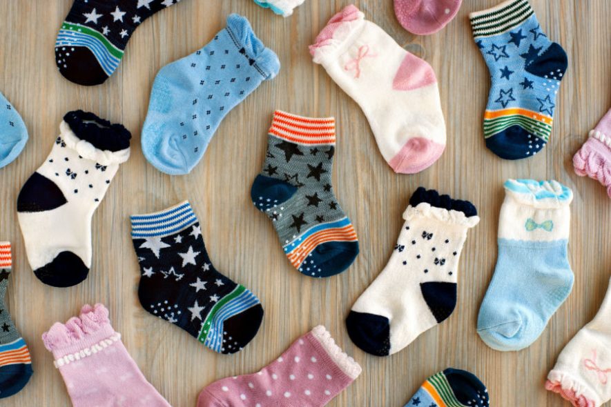 Different-colored newborn socks all over the floor.